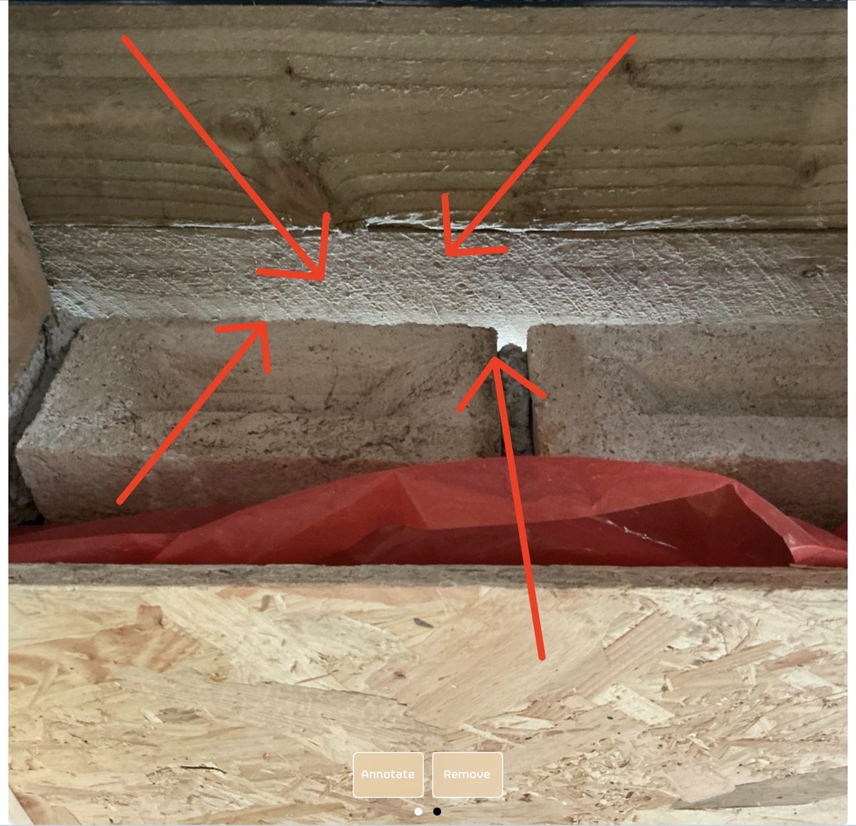 Attic gap between brickwork and timber beam with daylight visible through the front-left wall of a new build