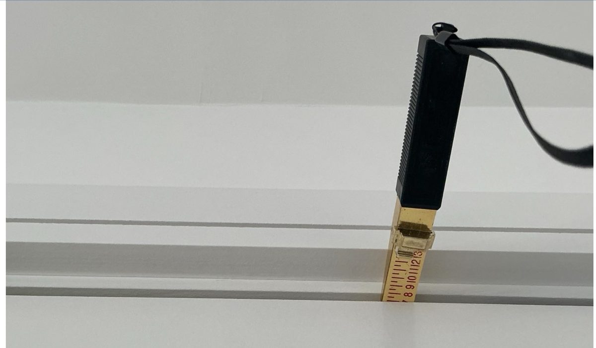 Tape measure showing an oversized clearance gap under a 1st-floor bedroom door, exceeding fire-regulation tolerances